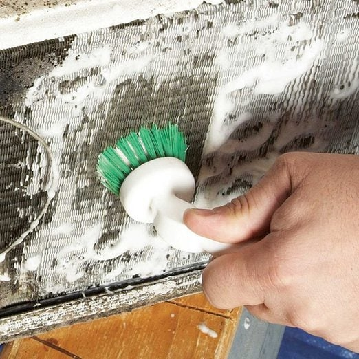 cleaning AC coils using detergent and brush